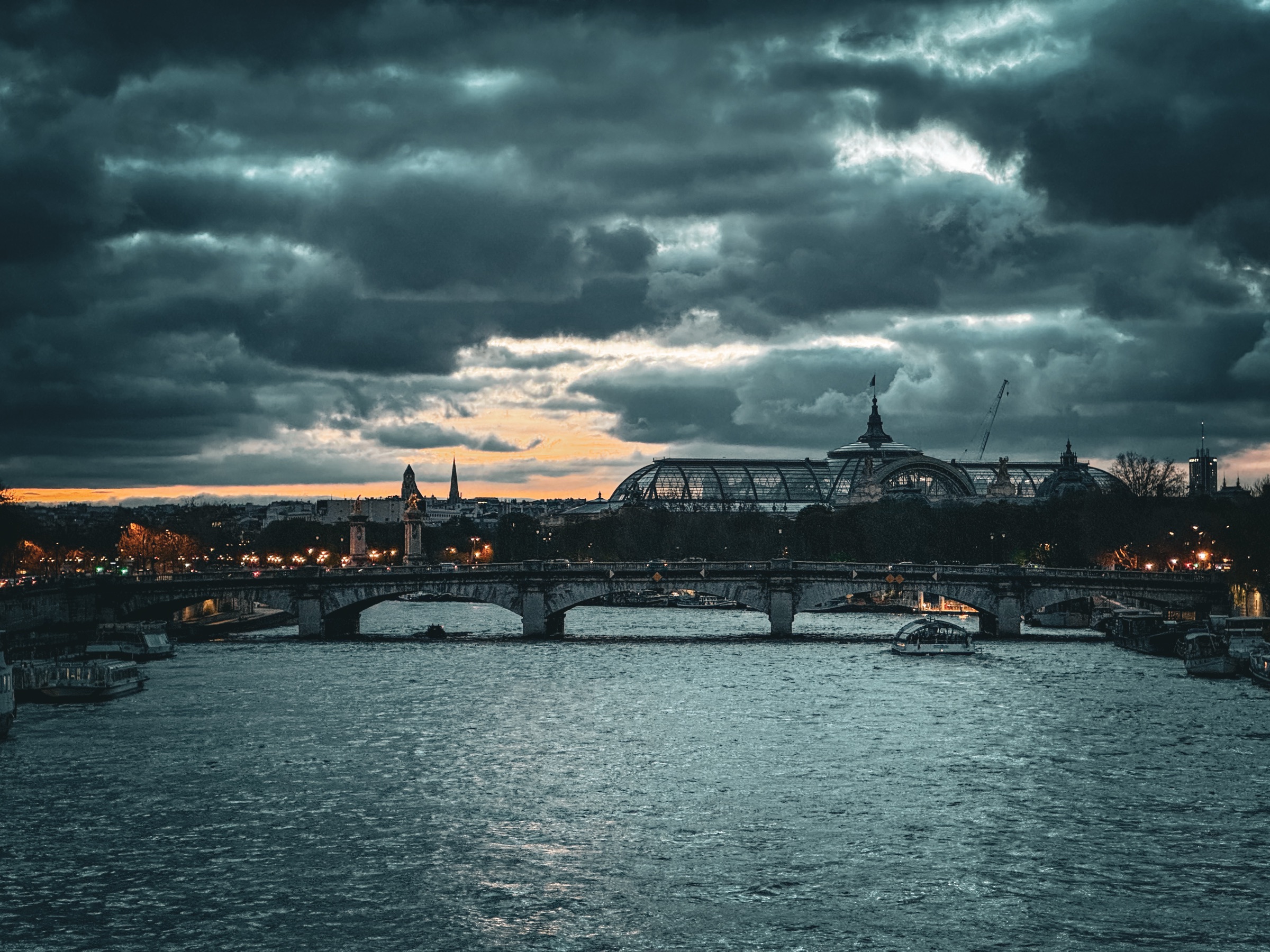 Pont sur la Seine et Grand Palais sous un ciel d'orage